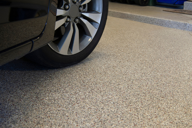 Garage epoxy flooring with a car driven on it