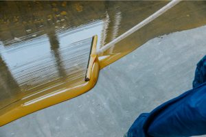 Industrial grade epoxy coating being applied by a worker